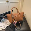 Elegante bolso bandolera marrón de pana para mujer con asas y elegante colgante de cuentas. - Marrón