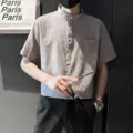 Vue détaillée de la chemise manches courtes pour homme avec col mao, patte de boutons et poche. - S / Hauts / Gris