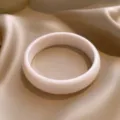 Elegante roomwitte ronde hars armband gepresenteerd op een beige satijnen achtergrond - Ronde Stijl (HB4514-1) / Wit