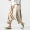Close-up of men's loose beige harem pants featuring a low crotch design and breathable fabric. - M / Khaki