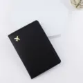 Dettaglio in primo piano della copertina per passaporto in pelle PU nera con logo aereo. - Nero
