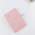 Primo piano dettagliato di una custodia per passaporto in pelle PU rosa con logo aereo dorato. - Rosa