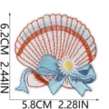 Close-up detail of the shell embroidery patch featuring blue bow and flower design. - Daisy Seashell (X27BK-13-07)