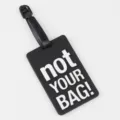 Black PVC luggage tag featuring clear white Not Your Bag text, durable travel accessory. - Black