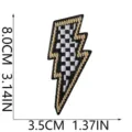 Detailaufnahme des bestickten Blitz-Patches mit schwarz-weißem Karomuster und goldenem Rand. - Schwarz Weiß Karo Goldrand Blitz (X33SD-078-04)