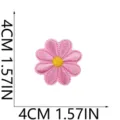 Primo piano della toppa ricamata a margherita rosa, dettaglio applicazione per vestiti. - W19HD-045-17