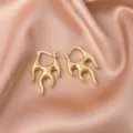 Macro detail of minimalist gold flame hoop earrings on a luxury satin backdrop - Flame-Shaped Hoop Earrings (E177) / Standard / Gold (E177)