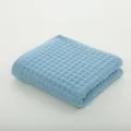 Serviette éponge gaufrée en coton bleu clair, pliée proprement sur fond uni pour usage quotidien. - Gris Bleu / 72x35cm