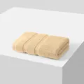 Beige cotton hand towel variant, soft plain woven towel displayed neatly on white surface. - White Oak