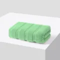 Serviette de visage pliée en pur coton vert clair, texture douce, unie simple usage. - Vert menthe