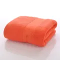 Effen oranje katoenen badhanddoek, zachte hotelkwaliteit absorberende handdoek netjes opgevouwen - Oranjerood