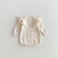 Detailed view of cream baby knit romper featuring delicate shoulder ruffles and geometric pattern. - 90cm / White Apricot