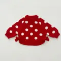 Close-up view of red knit baby sweater with white polka dots and side bows detail. - 66cm / Red