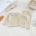 Detail of baby girl ribbed long sleeve top and pants set with delicate lace collar. - 66cm / Apricot