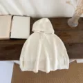 Baby knit hooded cape detail shot, showing soft cream texture, cozy autumn infant wear style. - 73cm / Off White