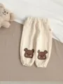 Vue détaillée du pantalon décontracté pour bébé avec broderie d'ours et tissu doux. - 66cm / Abricot