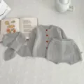 Dettaglio del set di maglioni lavorati a maglia per neonati grigi con sciarpa coordinata. - Set / Grigio / 66cm