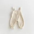 Detailed shot of baby ribbed romper with ruffled straps and embroidered chest frill. - 66cm / Apricot