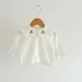 Close-up detail of white baby girl cotton blouse with cute collar embroidery and ruffles. - 80cm / Tops / Cream White Top