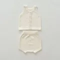 Detailed close-up view of cream baby knitwear set, sleeveless vest and cute bloomers. - 66cm / Top And Bottom / Off White