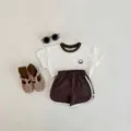 Süßes Sommer Freizeitset mit weißem Kurzarm T-Shirt und Shorts für Kleinkinder. - Kokosnuss