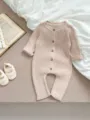 Nahaufnahme des Baby Strickoveralls mit weicher Rippstruktur und Holzknopfverschluss. - Charmantes Aprikose / 66cm
