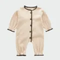 Detail des gerippten Baby-Bodys mit kontrastierender brauner Kante und vorderen Knöpfen. - 80cm / Khaki