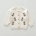 Detail of infant knit cardigan sweater with floral embroidery and wooden buttons in beige. - 66cm / Off-white Jacket