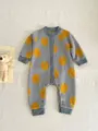 Detailed view of cute baby knit romper with orange print, cozy fabric, soft texture and buttons. - Grey Orange