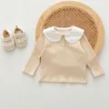 Close-up detail of infant baby ribbed long-sleeve top with sweet white peter pan doll collar. - 66cm / Tops / Apricot