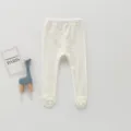 Détail de collants blancs pour bébé en tricot côtelé avec adorables fleurs sur les bas. - 66cm / Blanc