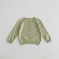 Détail de cardigan tricoté vert clair pour bébé avec jolis points popcorn et boutons. - Vert / 66cm