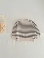Detailed view of a cute baby striped knit sweater in beige and black, soft and cozy pullover style. - Apricot Black Stripes