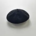 Infant black knitted beret detail shot, showcasing the soft fabric and cute top loop design. - One Size / Black