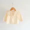 Nahaufnahme Detail der Baby Mädchen Langarm Bluse mit süßem Rüschenkragen und Knöpfen. - 66cm / Beige Aprikose