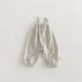 Detailed view of baby polka dot suspender jumpsuit, cotton fabric with black dots and elastic cuffs. - 73 / Bottoms / Black White Polka Dot