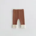 Close-up detail of infant ribbed knit leggings with brown body and contrast white cuffs. - 73cm / Brown
