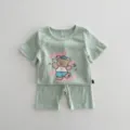 Vista dettagliata del set estivo da neonato con maglietta a maniche corte e pantaloncini. - 66cm / Parte Superiore e Parte Inferiore / Verde