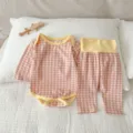 Primo piano dettagliato del body a quadri rosa e pantaloni a vita alta per neonati. - Rosa