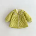 Detailed view of kids quilted coat featuring doll collar, green pattern and button closure. - 73cm / Green