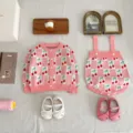 Detail view of baby knit cardigan and romper set with pink cherry checkered jacquard pattern. - 66cm / Two-Piece Set