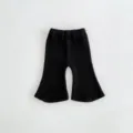 Detailed view of black knitted baby flare pants, soft cotton ribbed fabric, comfortable fit. - 66cm / Black