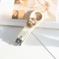 Coupe-ongles pliable couleur crème mignon avec décoration de fleur et nœud papillon. - Fleur
