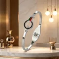 Close-up detail of luxury titanium steel bangle with red green stripe and rhinestone design. - Silver