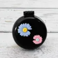 Compact folding hair brush with cute daisy flowers, portable round pocket massage comb for girls. - Daisy on Black Background