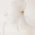 Pendientes de botón ovalados de acero de titanio chapado en oro 18k con flor de agosto. - Agosto - Amapola