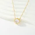Detalle en primer plano del deslumbrante colgante de circonita con delicada cadena dorada. - Estilo Circón Blanco