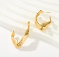 Pendientes dorados texturizados irregulares primer plano, joyería minimalista retro chic. - Pendientes de textura fundida en V