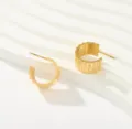 Primer plano de pendientes de aro en C de acero de titanio bañado en oro de 18k con borde ondulado. - Estilo de Borde Ondulado