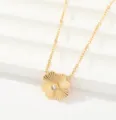 Detalle de collar con colgante de flor dorada, pétalos ranurados y cristal central brillante. - Trébol Texturizado